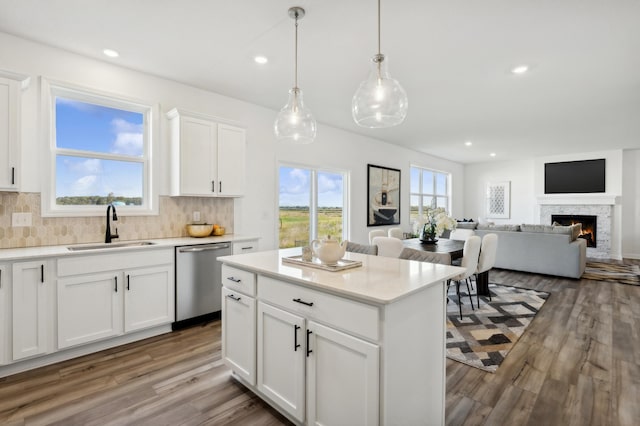 kitchen featuring white cabinets, light countertops, a sink, and dishwasher