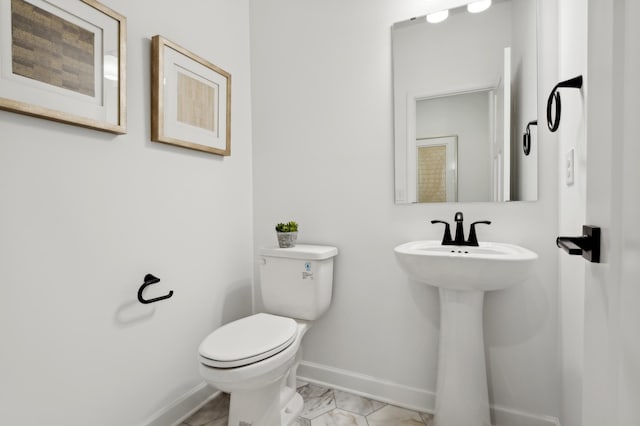 bathroom featuring marble finish floor, toilet, and baseboards