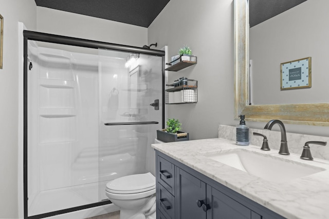 full bath with vanity, toilet, and a shower stall