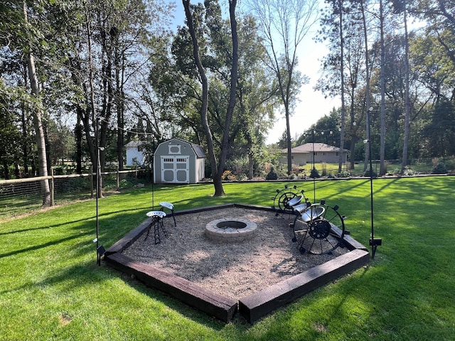 view of yard with an outdoor fire pit, fence, a shed, and an outdoor structure