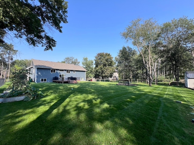 view of yard featuring an outbuilding, fence, and a wooden deck