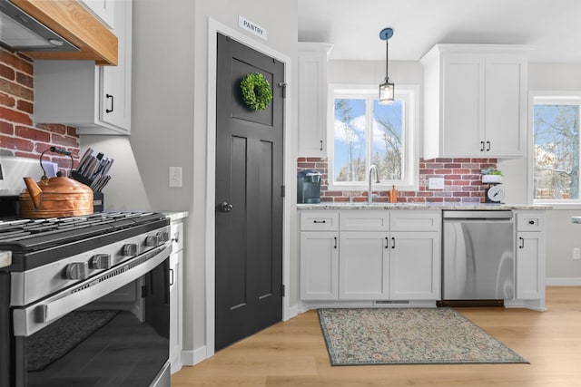 1752 209th Ave NE, East Bethel, MN 55011 - kitchen featuring stainless steel appliances, extractor fan, a sink, and white cabinets