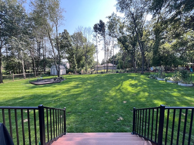 1752 209th Ave NE, East Bethel, MN 55011 - view of yard with a shed, a vegetable garden, an outdoor structure, view of scattered trees, and a wooden deck
