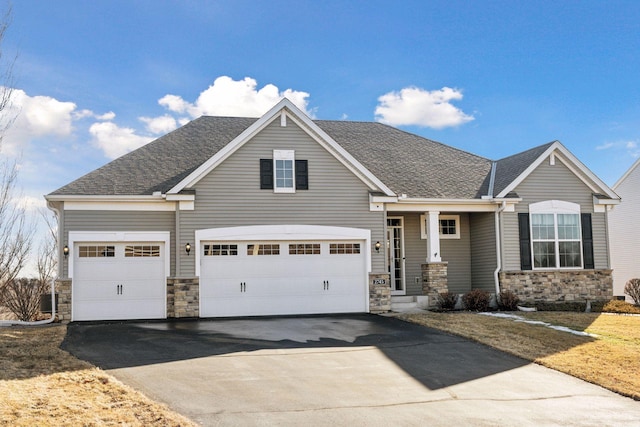 craftsman-style home featuring stone siding, aphalt driveway, and roof with shingles