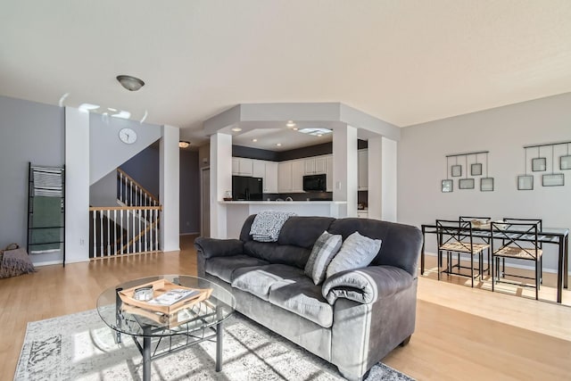 living area featuring light wood-type flooring and stairway