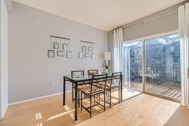 dining area featuring baseboards, visible vents, and wood finished floors