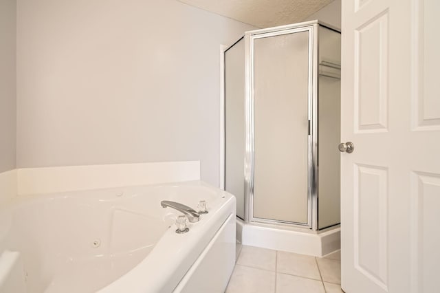 bathroom with tile patterned floors, a shower stall, a tub with jets, and a textured ceiling