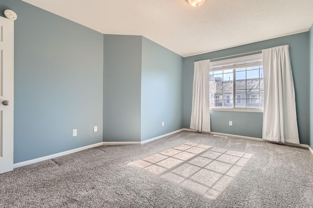 empty room with baseboards, a textured ceiling, and carpet