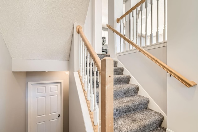 stairs featuring baseboards and a textured ceiling
