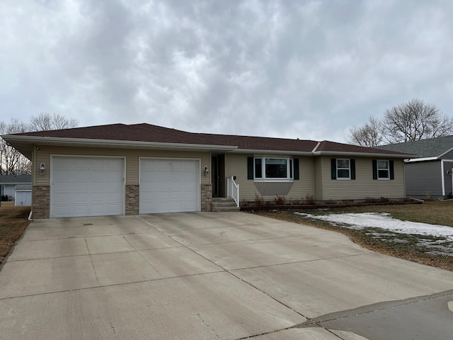 ranch-style home featuring driveway, brick siding, and an attached garage