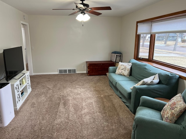 carpeted living room featuring a ceiling fan, visible vents, and baseboards