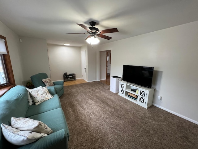 carpeted living room featuring ceiling fan and baseboards