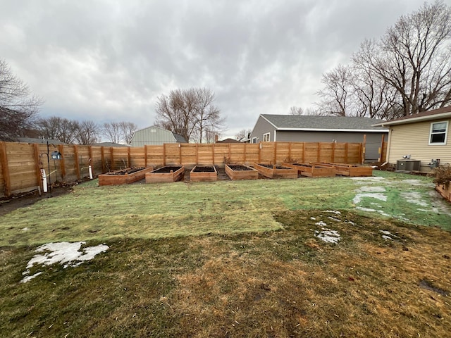 view of yard with a fenced backyard, a vegetable garden, and cooling unit