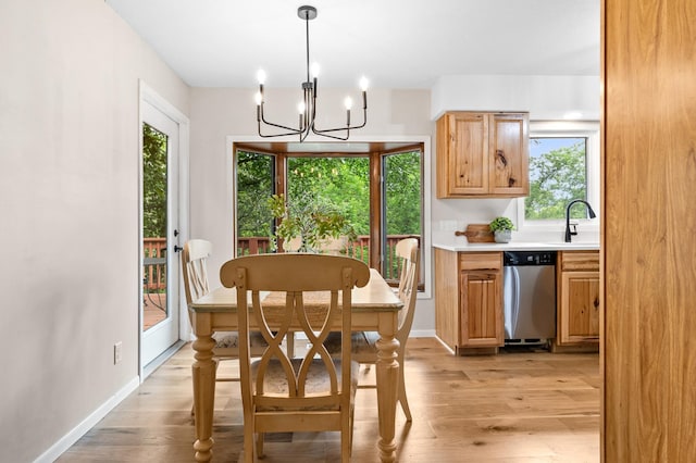 dining space featuring baseboards, a chandelier, and light wood-style floors