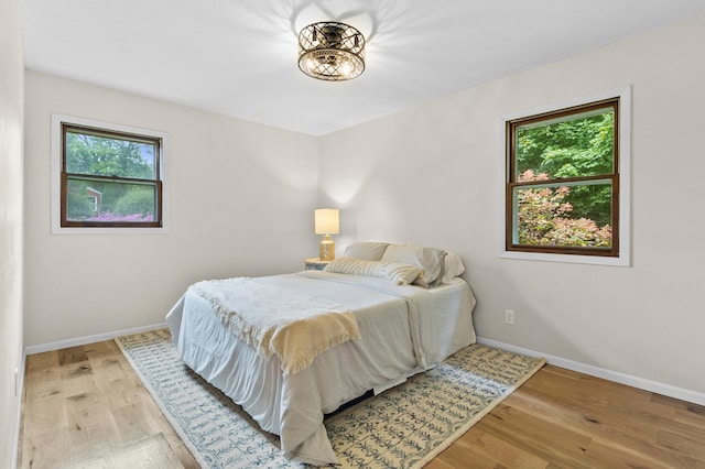 bedroom featuring light wood-style floors and baseboards