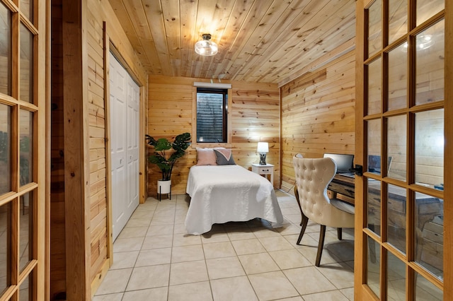 bedroom with wooden ceiling, wooden walls, french doors, and light tile patterned floors