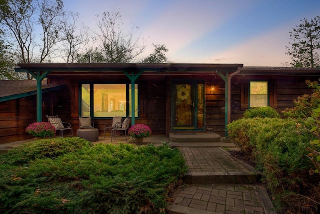 rear view of property featuring covered porch