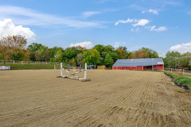 view of home's community featuring an outbuilding, a rural view, an enclosed area, and fence