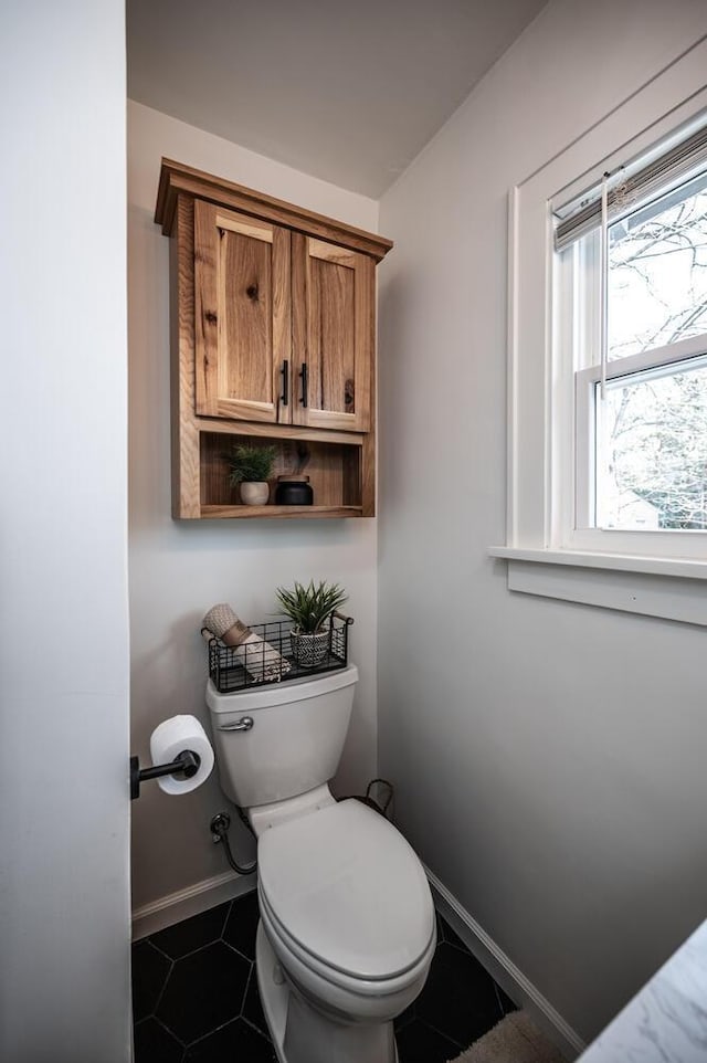 bathroom featuring tile patterned floors, baseboards, and toilet