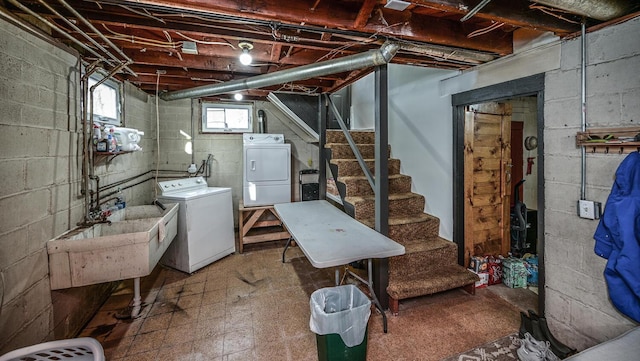 basement featuring a sink, tile patterned floors, stairs, and washing machine and clothes dryer