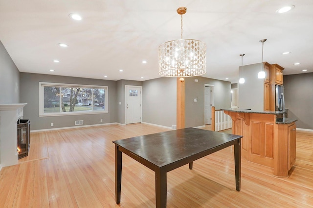 dining space featuring baseboards, visible vents, and light wood-style floors