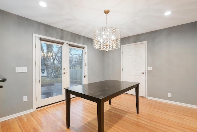 unfurnished dining area with recessed lighting, baseboards, a notable chandelier, and light wood-type flooring