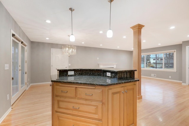 kitchen with baseboards, visible vents, light wood finished floors, and a center island