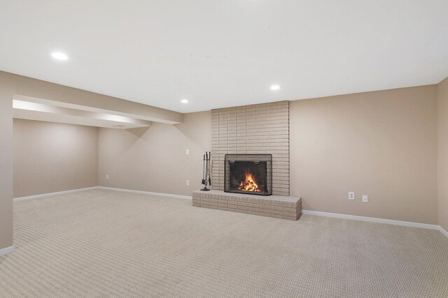 unfurnished living room featuring baseboards, carpet flooring, a brick fireplace, and recessed lighting
