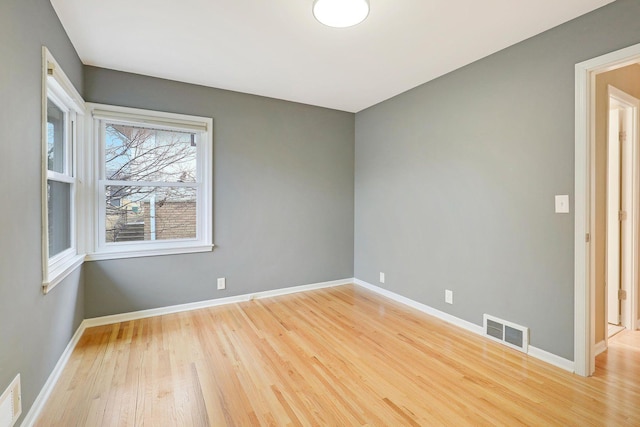 spare room with visible vents, light wood-style flooring, and baseboards