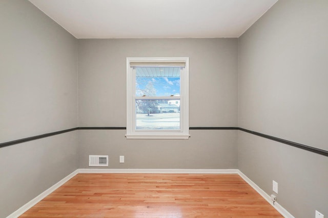 spare room with baseboards, visible vents, and light wood-type flooring