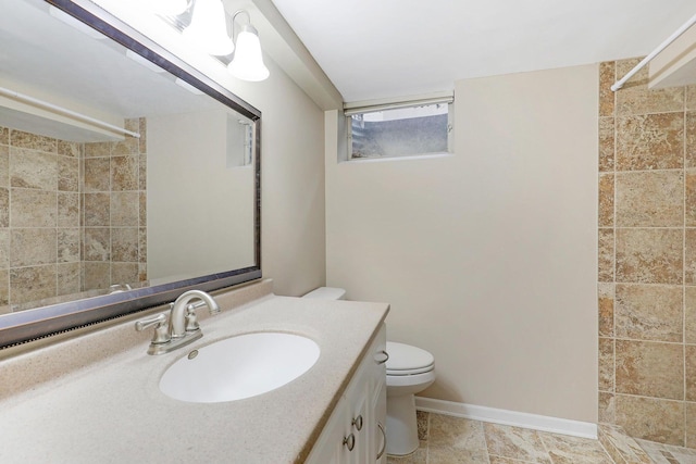 full bathroom featuring vanity, baseboards, toilet, and tiled shower
