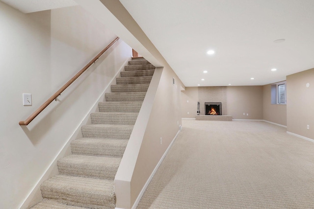 stairway with baseboards, a fireplace, carpet flooring, and recessed lighting