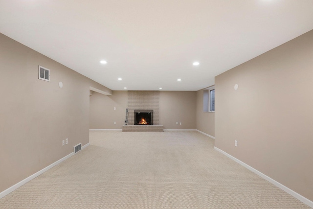 unfurnished living room featuring baseboards, a brick fireplace, recessed lighting, and visible vents
