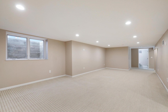 finished below grade area featuring baseboards, recessed lighting, and light colored carpet