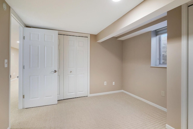 unfurnished bedroom featuring carpet floors, baseboards, and a closet