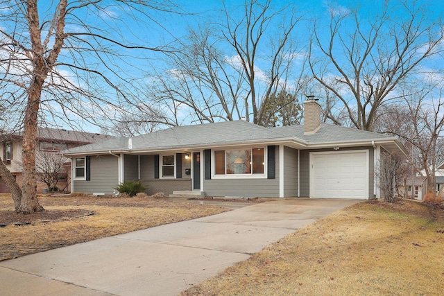 ranch-style home featuring a garage, a chimney, concrete driveway, and a front lawn