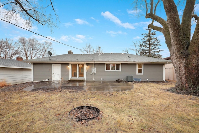 back of property featuring an outdoor fire pit, an outbuilding, a patio area, central air condition unit, and a storage unit