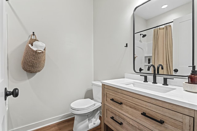 full bathroom with baseboards, a shower with shower curtain, toilet, wood finished floors, and vanity