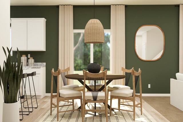 dining area featuring baseboards and light wood finished floors