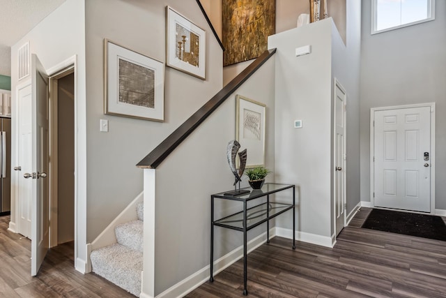 entrance foyer featuring visible vents, stairway, baseboards, and dark wood-style flooring