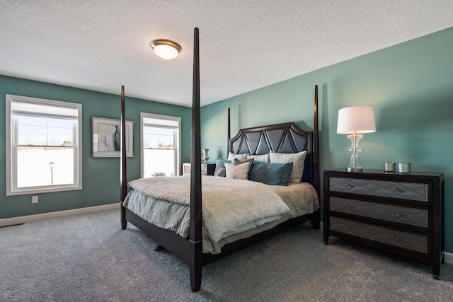 carpeted bedroom featuring baseboards and a textured ceiling