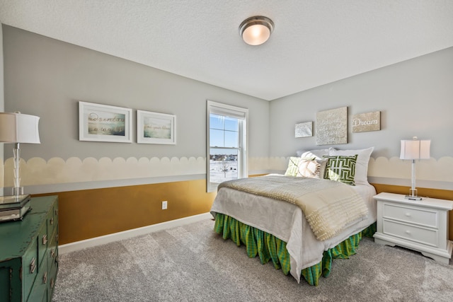 bedroom featuring carpet, baseboards, and a textured ceiling