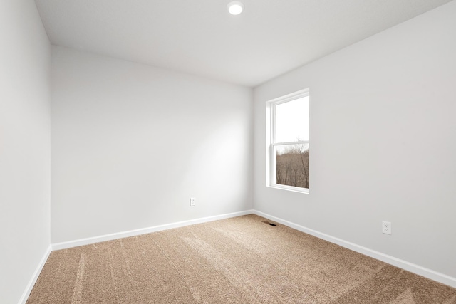 carpeted empty room featuring visible vents and baseboards