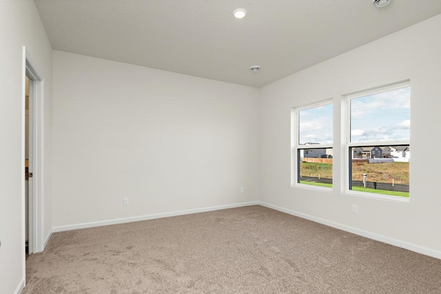 empty room with light colored carpet and baseboards