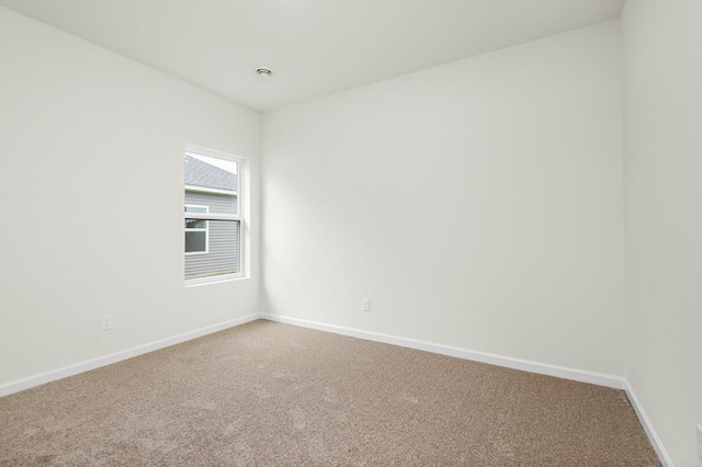 empty room featuring carpet flooring and baseboards