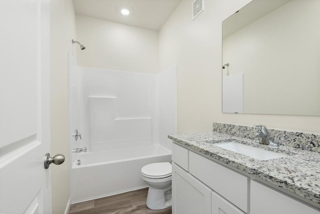 bathroom featuring toilet, wood finished floors, visible vents, vanity, and  shower combination