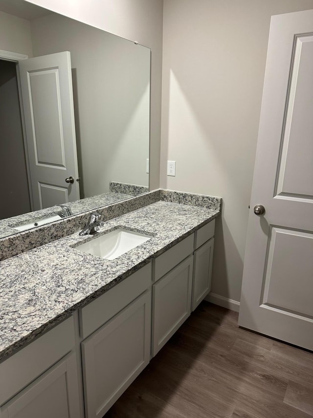 bathroom with vanity, baseboards, and wood finished floors