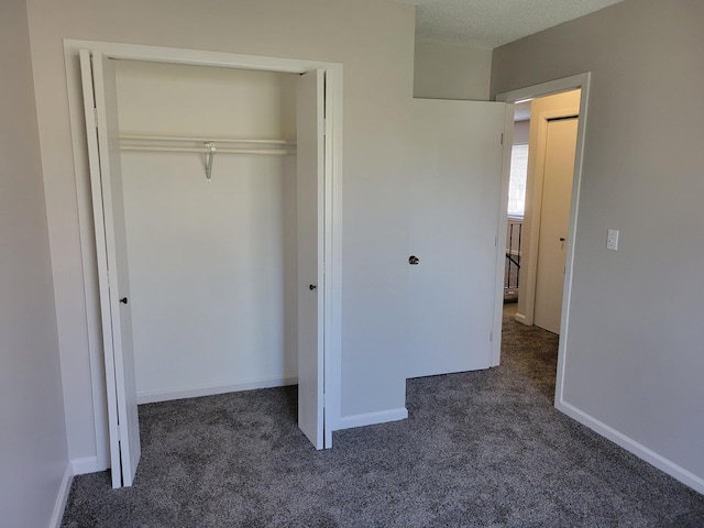 unfurnished bedroom featuring a closet, baseboards, and carpet flooring