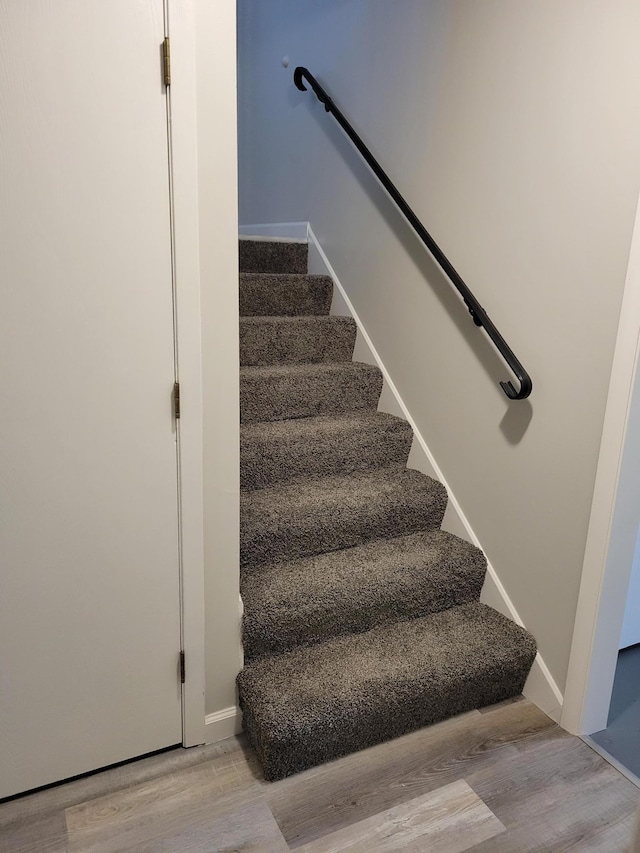 stairway featuring baseboards and wood finished floors