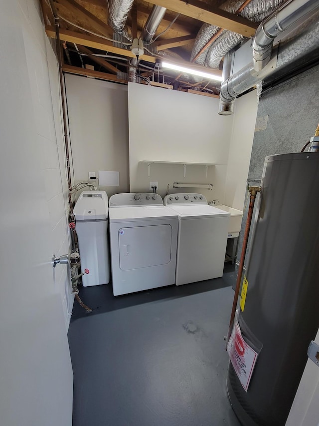 clothes washing area with laundry area, washing machine and dryer, water heater, and a sink